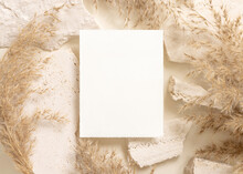 Blank Card Near Beige Travertine Stones And Dried Pampas Grass Top View, Greeting Mockup
