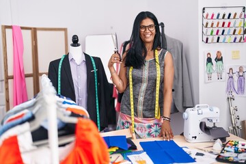 Canvas Print - Middle age hispanic woman tailor smiling confident cutting cloth at tailor shop