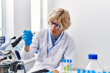 Canvas Print - Young blond man scientist holding sample with tweezer at laboratory