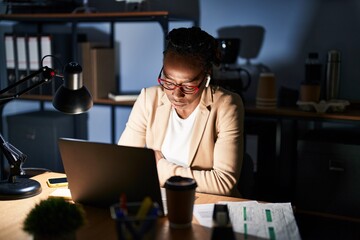 Wall Mural - Beautiful black woman working at the office at night with hand on stomach because indigestion, painful illness feeling unwell. ache concept.