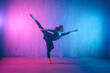 © Halfpoint - Modern dance girl dancer dancing in neon light doing gymnastic exercises in studio, copy space.