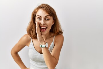 Sticker - Beautiful caucasian woman standing over isolated background hand on mouth telling secret rumor, whispering malicious talk conversation