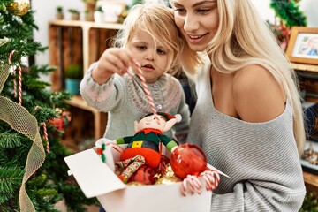 Sticker - Mother and daughter smiling confident decorating christmas tree at home