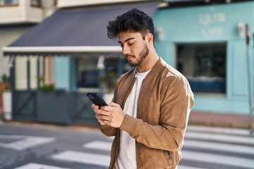 Canvas Print - Young hispanic man using smartphone at street