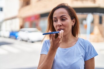 Wall Mural - Young woman smiling confident talking on the smartphone at street