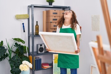 Sticker - Young caucasian woman looking at canvas angry and mad screaming frustrated and furious, shouting with anger looking up.