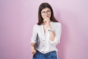 Sticker - Young caucasian woman holding laptop thinking worried about a question, concerned and nervous with hand on chin