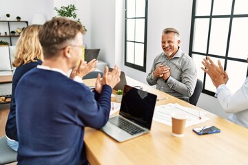 Wall Mural - Group of middle age business workers smiling and clapping to partner at the office.