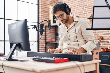 Wall Mural - Young hispanic man musician playing piano keyboard at music studio