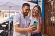 © Krakenimages.com - Man and woman couple smiling confident using smartphone at street