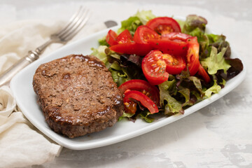 Wall Mural - three fried ground meat with fresh salad on white plate