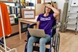 © Krakenimages.com - Young brunette woman as volunteer on donations stand sitting on wheelchair stressed and frustrated with hand on head, surprised and angry face