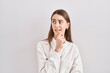 © Krakenimages.com - Young caucasian woman standing over isolated background thinking worried about a question, concerned and nervous with hand on chin