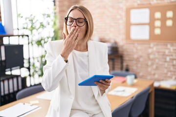 Poster - Young caucasian woman working at the office wearing glasses bored yawning tired covering mouth with hand. restless and sleepiness.