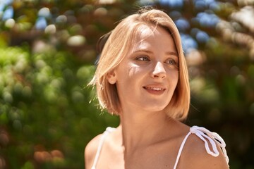 Poster - Young blonde woman smiling confident looking to the side at park