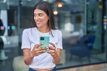 Poster - Young beautiful hispanic woman smiling confident using smartphone at street