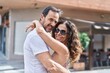 © Krakenimages.com - Man and woman couple hugging each other at street