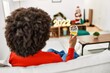 © Krakenimages.com - Young african american woman toasting with wine sitting by christmas decor at home