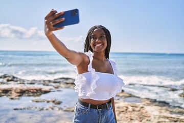 Canvas Print - Young african american girl smiling happy make selfie by the smartphone at the beach.