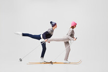 Weekend Activities.Two Funny Retro Skiers In Warm Winter Casual Wear Skiing Isolated On Grey Background. Retro, Vintage, Sport, Holidays, Hobbies Concept