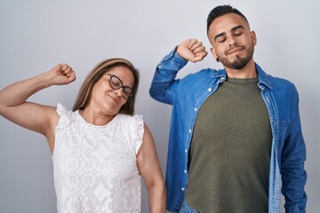 Poster - Hispanic mother and son standing together stretching back, tired and relaxed, sleepy and yawning for early morning