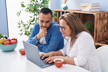 Wall Mural - Man and woman mother and son drinking coffee using laptop at home