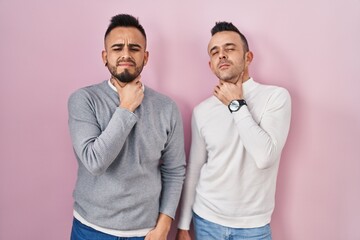 Canvas Print - Homosexual couple standing over pink background touching painful neck, sore throat for flu, clod and infection