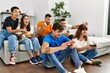 © Krakenimages.com - Group of young friends smiling happy playing video game at home.