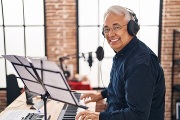 Wall Mural - Senior man musician playing piano keyboard at music studio