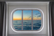 Blick durch das Kabinenfenster eines Kreuzfahrtschiffs bei Abendstimmung