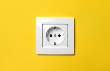 Power socket on yellow wall. Electrical supply