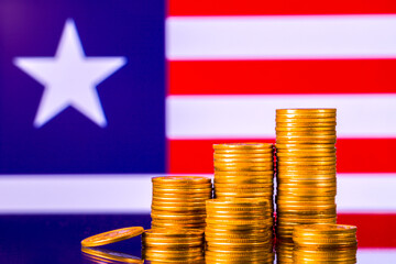 A stack of gold coins on the background of the flag of 
Liberia. Country economy concept