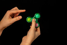 Child's hand playing with a fidget spinner toy