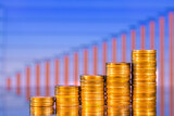 Fototapeta Do przedpokoju - Stacks of golden coins on the background of a blurred business financial graph. Digital business and stock market financial indicator.