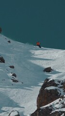 Poster - Vertical breathtaking view of a person skiing in the snowy mountain in the highlands