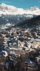 Poster - Vertical breathtaking aerial view of the snowy town on the mountain in the highlands