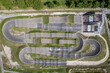 © AmazingAerialAgency - Aigle, Switzerland - 19 August 2022: Aerial view of a kart racing circuit in Aigle, Switzerland.