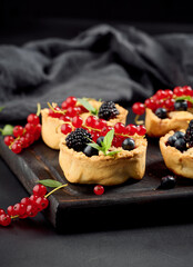 Canvas Print - Round mini fruit pie on a wooden board, close up