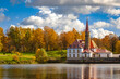 Priory Palace on the shore of the lake in Gatchina near St. Petersburg in the autumn afternoon, the castle against the background of the autumn forest