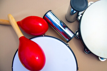 metal and wooden maracas and tambourine on a beige background