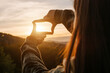© Yura Yarema - Business planning, strategy and vision concept. Close-up of young female making frame gesture with amazing beautiful sunset in mountains. Woman capturing sunrise. Copy space for promotion content