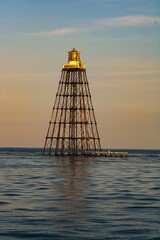 Wall Mural - Beautful view of the Sand Key lighthouse surrounded by water against the blue sky