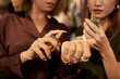 © DragonImages - Women choosing new perfume at store