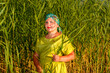 © finist_4 - A woman in a Kisui Rosh headscarf and a green dress in reeds.