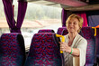 Senior Woman sitting on travel Bus and waiting for excursion. Interesting life in retirement for elderly woman concept