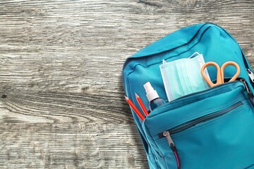 Poster - School modern backpack with stationery on the desk