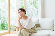 © taka - リビングで考え事をする女性