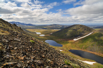 Wall Mural - Summer mountain landscape. Beautiful nature of the Arctic. View from the mountainside to the hills, mountain lakes and tundra. Traveling and hiking in the wilderness of the polar region. July.