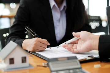 Wall Mural - Real estate agent discussing and explaining insurance contract signing to client.