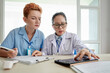 © DragonImages - Doctor with nurse using tablet pc
